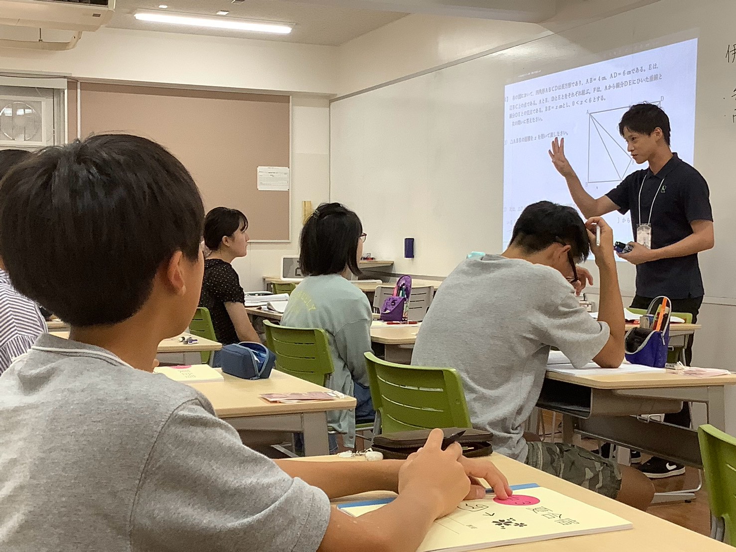 先生の説明を聞きながら授業を受ける生徒たち