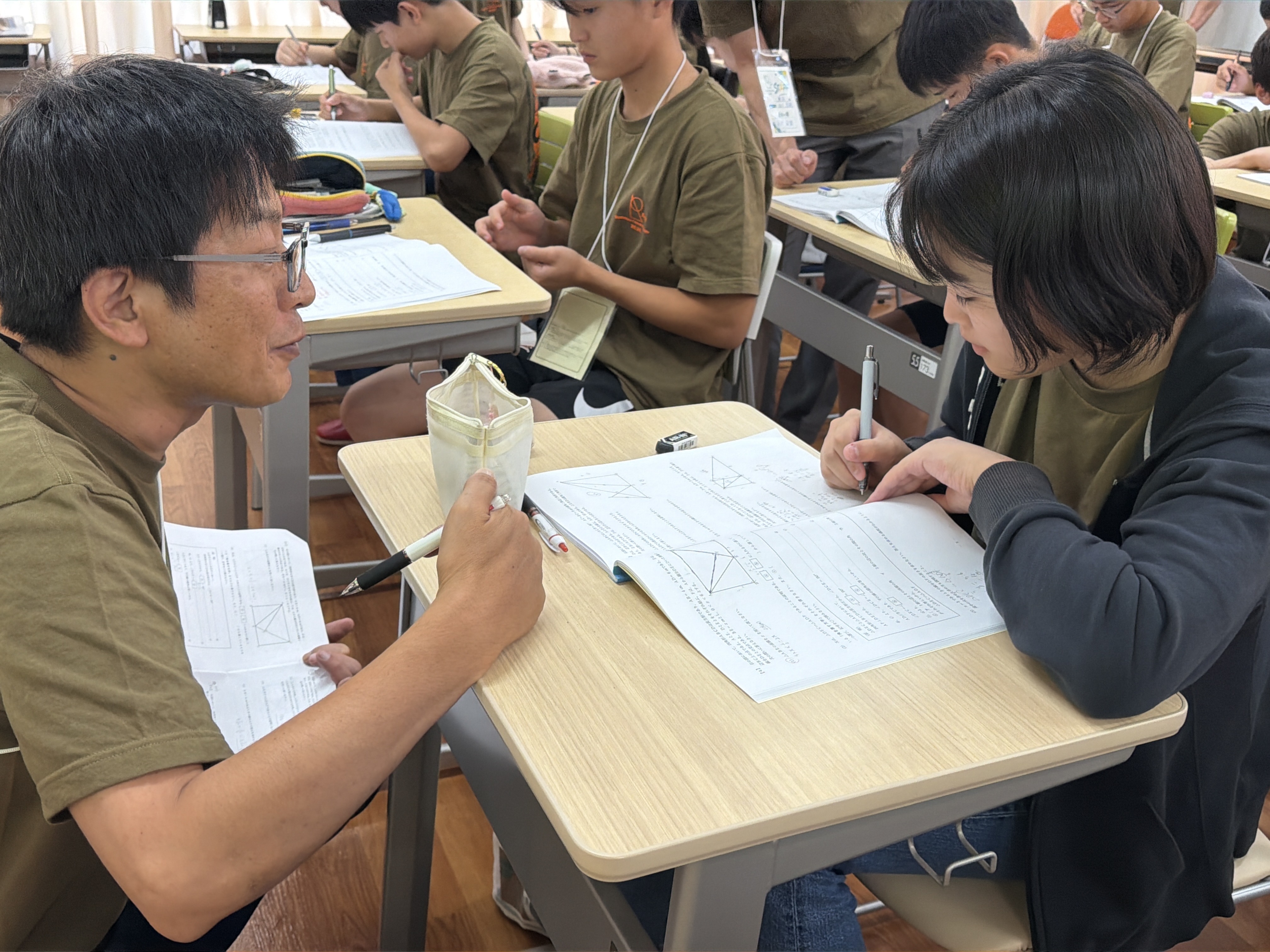 先生が生徒の手元を見ながら個別にサポートする様子