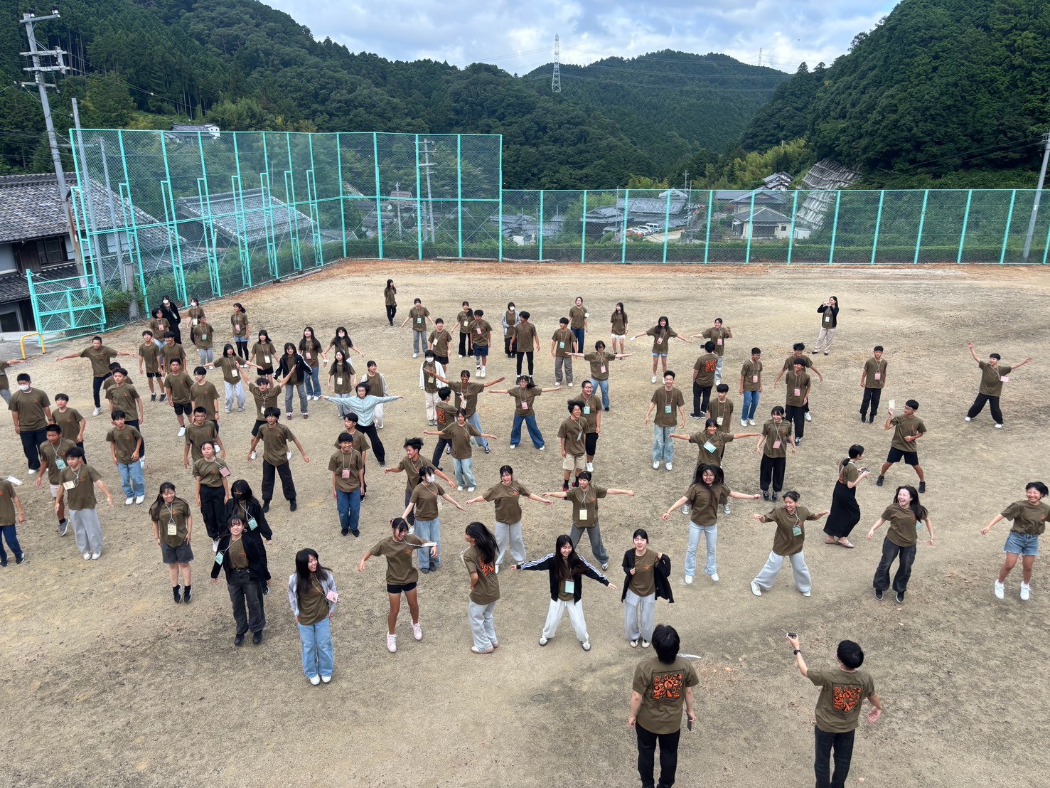 屋外で朝の体操をする生徒たち